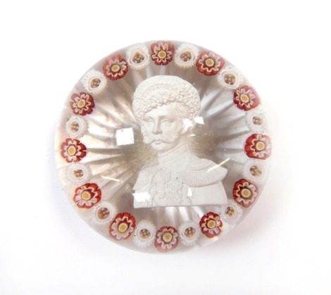 A 19thC Continental sulphide and millefiori glass paperweight, decorated with the bust portrait of a Russian Emperor, possibly Nicholas I, within alternating red and white millefioris, on a star cut base, 7cm diameter. (AF)