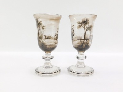 A pair of early 19thC Continental wine glasses, the trumpet shaped bowl painted in shades of grey with pastoral figures in a landscape, on a banded and teardrop included single knop stem, raised on an outswept conical foot, 16cm high. - 2