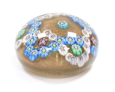 A Clichy millefiori glass paperweight, floral design, against a gold eventurine ground, 8.5cm diameter.