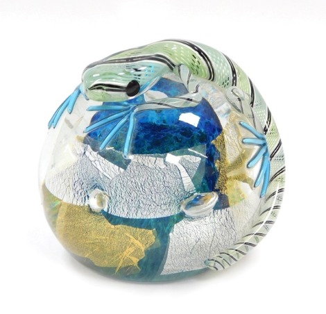 A Twists glass paperweight, designed by Mike Hunter, moulded over the body with a lizard, 10.5cm diameter.