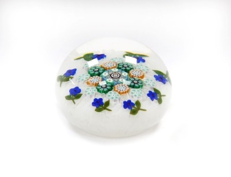 A Peter McDougall millefiori and scrambled latticino glass paperweight, with an outer band of violets, dated cane for 2010, bears paper label, 7cm diameter.