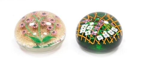 A Perthshire floral paperweight, decorated with trailing flowers on a trellis, green ground, underside dated cane for 1992, 8.5cm diameter, and a further paperweight, decorated with pink millefiori flowers, green stems and leaves against a gold aventurine