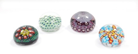 A vintage millefiori ink well paperweight, 8.5cm wide, and three further millefiori paperweights, of varying designs, each 7.5cm wide. (4, AF)
