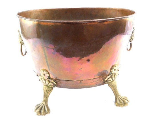 A Victorian copper and brass log basket, the shaped oval basket, on claw feet with lion mask and ring handles, 33cm high, 44cm wide.