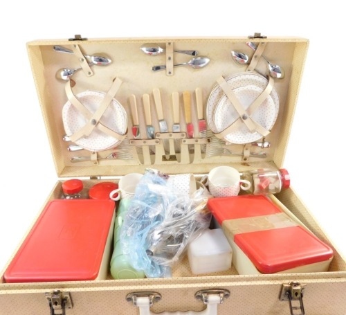 A Brexton picnic hamper, in cream spotted case, with brass buckles and supports, with plastics pots and ceramic plates, possibly incomplete, 58cm wide, 43cm deep.