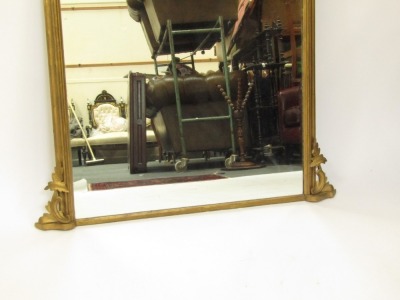 A Victorian giltwood overmantel mirror, the arched top with scroll leaf supports to each side, on bevelled mirror plate, 129cm x 105cm. (AF) - 2