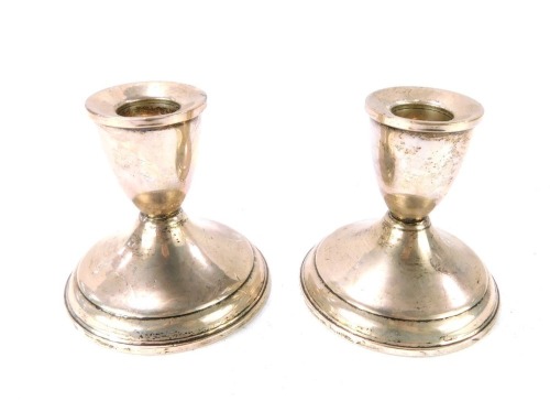 A pair of silver dwarf candlesticks, each with a ribbed top on a weighted base, stamped Sterling, 11¾oz all in, 8cm high.