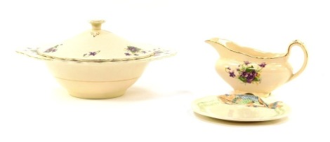 A Clarice Cliff Newport pottery fish plate, printed marks, together with a Royal Staffordshire Pottery vegetable tureen and cover, and a gravy boat, decorated with violets. (3)