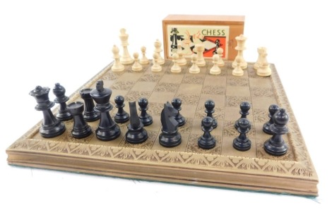 An early 20thC French cased wooden chess set, with a resin chess board, the king 5cm high.