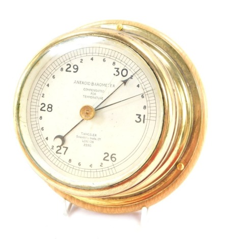 A T Wheeler aneroid barometer, in copper case on wooden plaque, 11cm diameter.