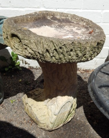 A reconstituted bird bath, with shaped top, on bark effect base, 43cm high.