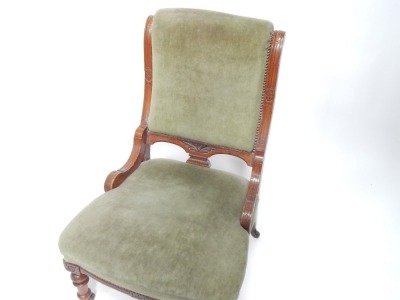 An Edwardian oak nursing chair, with turned legs, terminating in castors, 90cm high. - 2