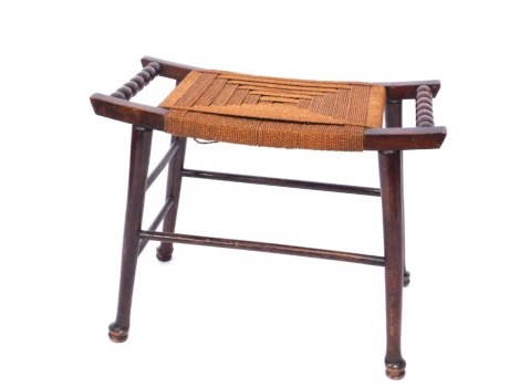 An early 20thC oak rush seated Arts & Crafts Thebes type stool, with bobbin turned handles on out splayed legs, 50cm high, 65cm wide, 30cm deep.