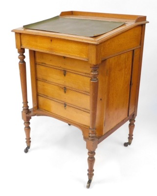 A Victorian oak clerk's desk, with galleried top with slope revealing desk top with the retailer's label for George Spademan, Cabinet Maker and Upholsterer, Stamford., over four fall flap drawer fronts, with Wellington locking action, opening to reveal pi