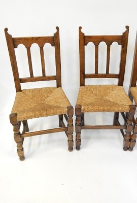 A set of four reproduction oak rush seated dining chairs, each with turret back and rush seat. - 2