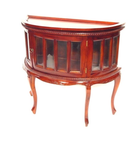 A reproduction demi lune display cabinet, the moulded top, above rectangular panel doors, on reeded border, with out splayed legs, 79cm high, 84cm wide, 35cm deep.