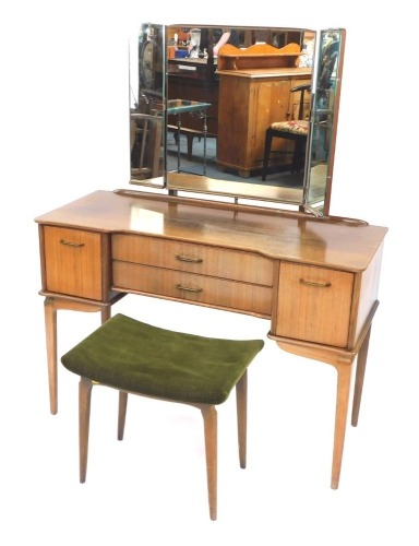 A 1960's hardwood dressing table, with triple mirror, above two drawers and two cupboards, on tapered legs, with associated stool, 142cm high, 107cm wide, 44cm deep. The upholstery in this lot does not comply with the 1988 (Fire & Fire Furnishing) Regulat