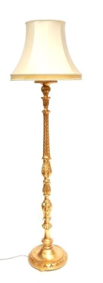 An early 20thC gilt finish standard lamp, with bulbous turned stem and cream shade, with fittings, 150cm high.