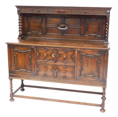 An early 20thC oak dresser, the carved panelled back with two barley twist columns on sideboard base, with arrangement of two drawers and two cupboards, on rectangular base with bun feet, 147cm high, 153cm wide, 52cm deep.