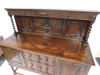 An early 20thC oak dresser, the carved panelled back with two barley twist columns on sideboard base, with arrangement of two drawers and two cupboards, on rectangular base with bun feet, 147cm high, 153cm wide, 52cm deep. - 2