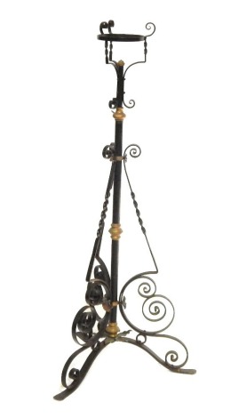 A Victorian wrought iron oil lamp base, in black finish with brass highlights, on tripod base, 115cm high.