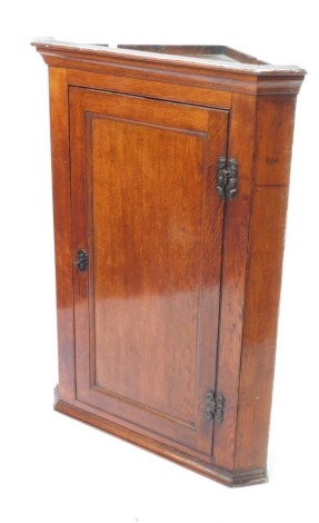 A 19thC oak hanging corner cupboard, with single door, with brass escutcheons, 101cm high, 65cm wide, 45cm deep.