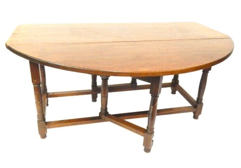 An 18thC style mahogany gate leg dining table, with three plank top on a turned base, 73cm high, 180cm wide, 150cm deep.