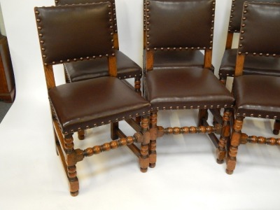 A set of six early 20thC Jacobean style oak dining chairs, each with a brown leather studded seat. - 2