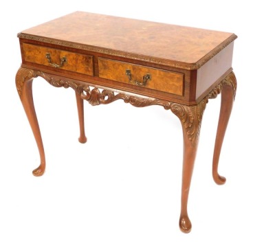 A reproduction burr walnut writing desk, with carved border and two drawers, on cabriole legs, 80cm high, 87cm wide, 46cm deep.