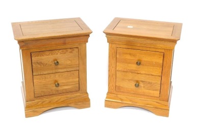 A pair of oak bedside cabinets, each with two drawers, 63cm high, 52cm wide, 38cm deep.