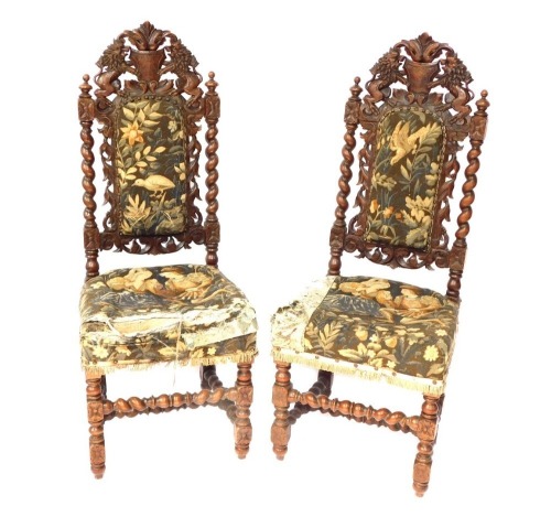 A pair of 19thC carved oak hall chairs, the back with single crest and two lions, on barley twist supports, 118cm high.