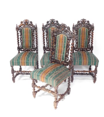 A set of four 19thC carved oak hall chairs, each with crest and lion top, on green striped material base, on barley twist supports, 115cm high.