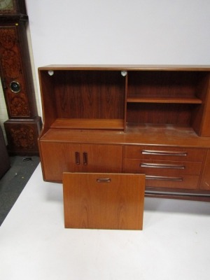 A mid century teak sideboard, with bookshelf top and cocktail cabinet, above two cupboard doors and three drawer central section, on shaped supports, 125cm high, 190cm wide, 50cm deep. - 3