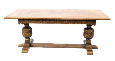 An early 20thC oak refectory table, with bulbous finials, on trestle base, 72cm high, 183cm wide, 83cm deep.