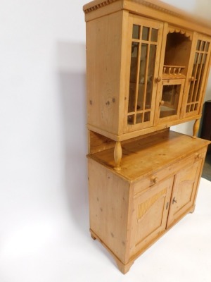 A stripped pine kitchen dresser, the top with three glazed doors, above base with arrangement of one long drawer and two cupboard doors, on bracket feet, 182cm high, 113cm wide, 48cm deep. - 3