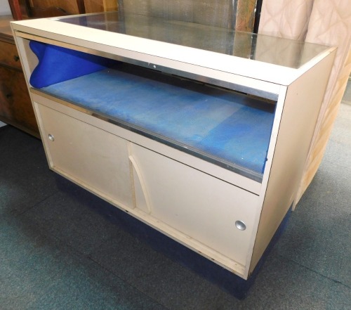 A jewellery counter, with cream supports, and glass inserts, cupboard back, 91cm high, 121cm wide, 60cm deep.