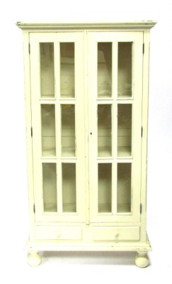 A 19thC cream painted display cabinet, of rectangular form with two glazed doors, each with six paneled windows, above two drawers, on block base, with bun feet, 180cm high, 96cm wide, 45cm deep.