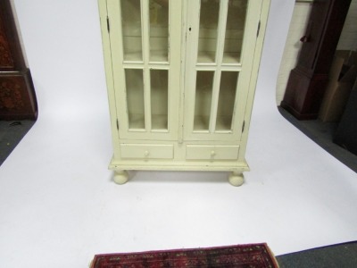 A 19thC cream painted display cabinet, of rectangular form with two glazed doors, each with six paneled windows, above two drawers, on block base, with bun feet, 180cm high, 96cm wide, 45cm deep. - 2