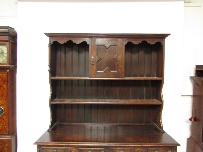 An early 20thC oak dresser, the plate rack top with two shelf section and single cupboard door, on moulded supports with sideboard base, with two drawers and two cupboard doors, 193cm high, 132cm wide, 50cm deep. - 3