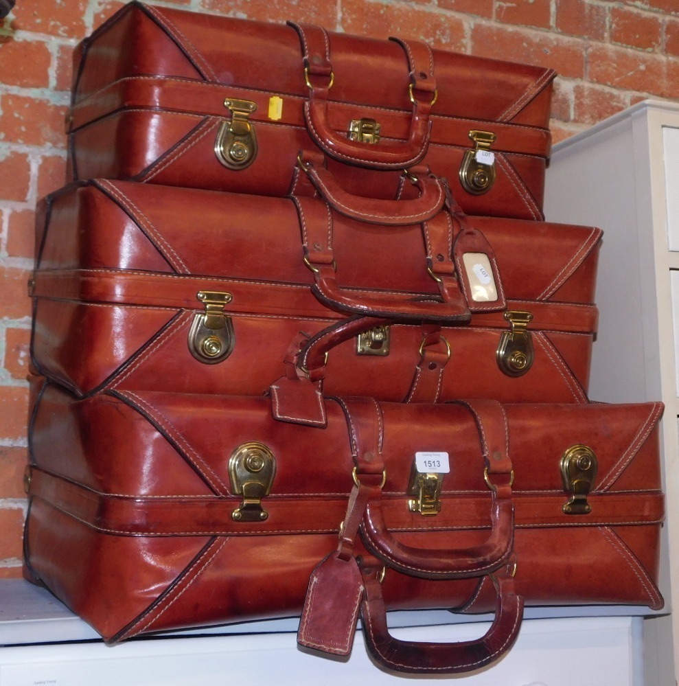 A set of three leather travel cases, graduated in size.