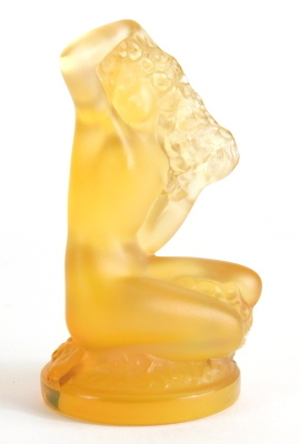 A 20thC Lalique amber coloured glass figure of a mermaid, kneeling, script mark, 9cm high.