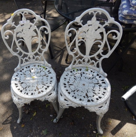 A pair of Coalbrookdale style aluminium garden chairs, each painted in silver.