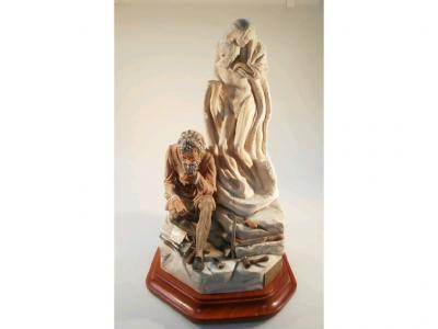 A large porcelain Capo di Monte figure of Michelangelo sat next to a unfinished