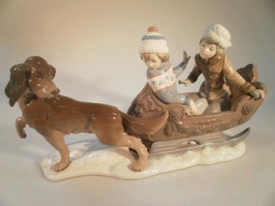 A large Lladro porcelain group of two children in a sledge being pulled by a dog