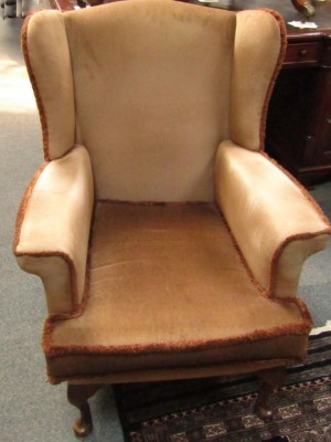 A Parker Knoll wingback armchair, upholstered in brown fabric. The upholstery in this lot does not comply with the 1988 (Fire & Fire Furnishing) Regulations, unless sold to a known exporter or upholsterer it will be cut from the frame before leaving the p