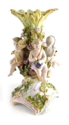 An early 20thC Sitzendorf porcelain centrepiece, formed with central bough surrounded by children, on a shaped base, raised with flowers with gilt highlights, double cross marks beneath, 30cm high.