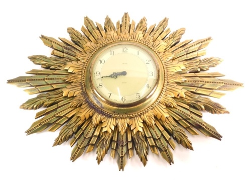 A 20thC Smith's sunburst clock, with 17cm diameter Arabic face, with pierced pointers, in shaped case, 48cm high.