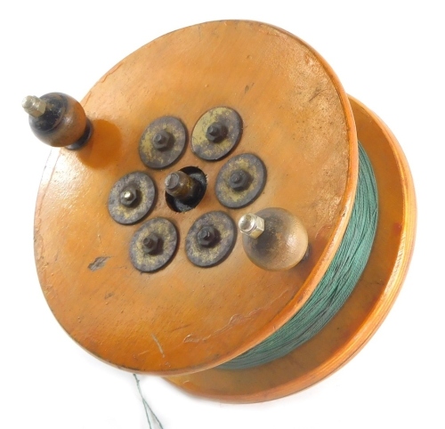 A large oak cased sea fishing reel, with metal and wooden mounts, 26cm diameter.