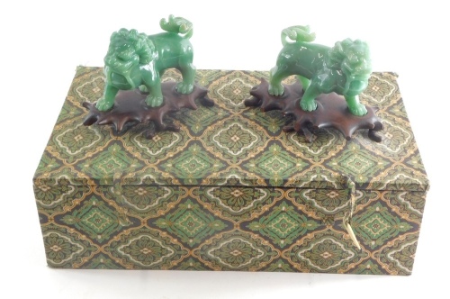 A pair of Chinese jade coloured Peking glass figures of dogs of fo, 12cm high, on wooden plinth bases. (boxed)