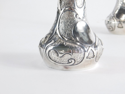 A pair of Art Nouveau vases, with cylindrical stems, bulbous bodies and a blind fret decoration with lotus flowers, on circular feet marked 95 white metal, 16cm high. (2) - 2